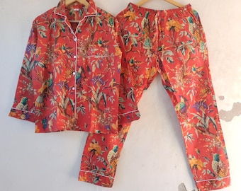 May include: Red pajama set with a bird and floral print. The top has a button-up front and long sleeves. The pants have an elastic waistband.