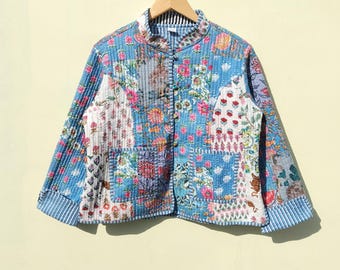 May include: A blue quilted jacket with a floral patchwork design. The jacket has a mandarin collar, a button closure, and long sleeves.