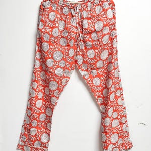 Puede incluir: Pantal&oacute;n de pijama rojo con estampado floral blanco. El pantal&oacute;n tiene cintura con cord&oacute;n y un ajuste holgado.