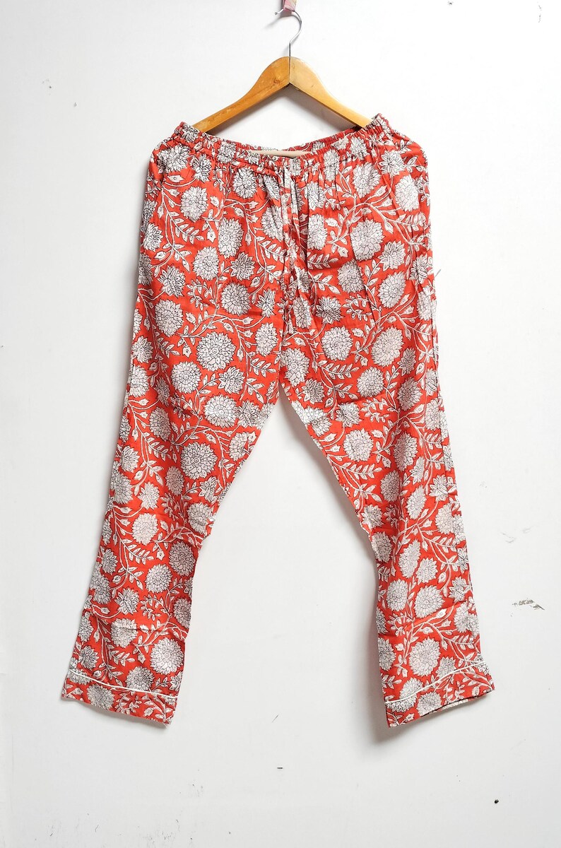 Puede incluir: Pantal&oacute;n de pijama rojo con estampado floral blanco. El pantal&oacute;n tiene cintura con cord&oacute;n y un ajuste holgado.