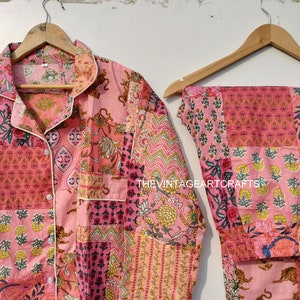 Peut inclure: Ensemble pyjama en coton rose et blanc avec un motif patchwork composé d'imprimés floraux et animaliers. L'ensemble comprend une chemise à manches longues avec un devant boutonné et un pantalon assorti.