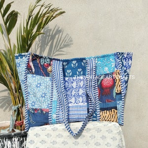 Peut inclure: Un sac fourre-tout en patchwork bleu et blanc avec un imprimé floral et fruitier. Le sac a deux longues lanières et est fait de tissu en coton. Le texte "THEVINTAGEARTCRAFTS" est imprimé sur le sac.