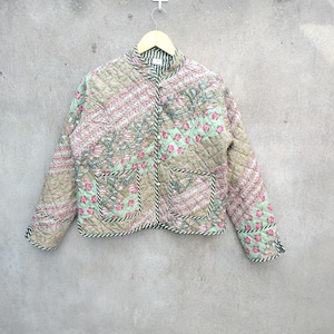 May include: A green quilted jacket with a floral print and black trim. The jacket has a mandarin collar and a button closure.