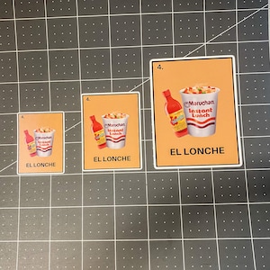 May include: A set of three stickers featuring a graphic of a cup of instant noodles and a bottle of hot sauce. The stickers have the text "EL LONCHE" and "Maruchan Instant Lunch" on an orange background.