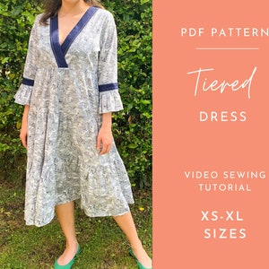 May include: A PDF pattern for a tiered dress with a navy blue trim. The pattern includes a video sewing tutorial and is available in sizes XS-XL.