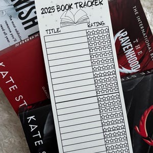 May include: A white printable book tracker for 2025 with a title and rating section. The rating section has 5 stars for each book. The tracker is on top of a stack of books.