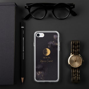 May include: A clear phone case with a black background and gold glitter. The case features a gold crescent moon with the words "MOON Waxing Crescent" printed below it.