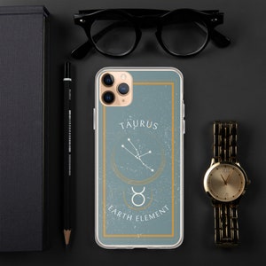 May include: A clear phone case with a blue background and gold accents. The case features a zodiac sign, Taurus, with the constellation and the text "Taurus Earth Element".