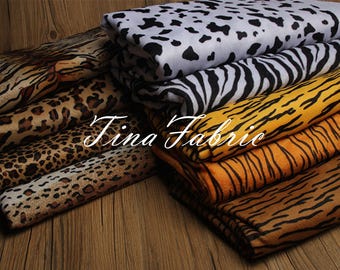 May include: A stack of different animal print fabrics, including zebra, leopard, and tiger prints. The fabrics are all in various shades of brown, black, white, and yellow.