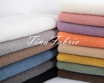 May include: A stack of different colored faux fur fabrics. The fabrics are soft and fluffy, and they would be perfect for making blankets, pillows, or other home decor items.