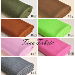 May include: A collection of seven fabric swatches in various colours, including green, brown, orange, lime green, pink, grey, and dark grey. Each swatch is folded and labelled with a number, from #41 to #47. The text "Tina Fabric" is visible in the centre of the image.