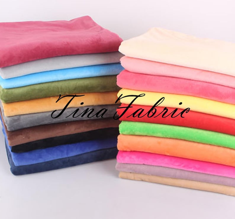 May include: A stack of colorful fabric swatches in various shades of pink, blue, green, orange, yellow, and brown. The fabric is soft and plush, and it would be perfect for crafting projects or home decor.