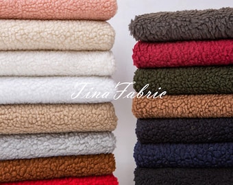 May include: A stack of 10 different colored faux fur fabric swatches. The colors are pink, white, beige, gray, brown, red, dark gray, green, brown, and navy blue.