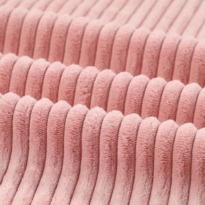 May include: Close-up of a soft, pink corduroy fabric with a ribbed texture.