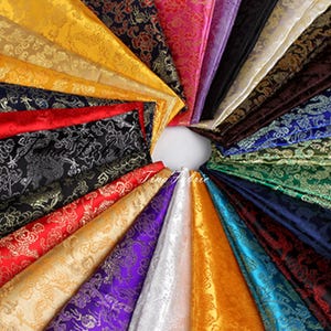 May include: A variety of patterned fabrics in different colors, including gold, red, purple, blue, and green. The fabrics have a repeating design of clouds and dragons. The fabrics are arranged in a circle, with the text "Tina Fabric" visible in the center.