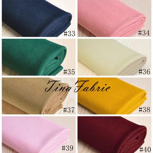 May include: A collection of ten fabric swatches in various colours, including navy blue, pink, green, beige, yellow, and burgundy. Each swatch is folded and labelled with a number from 33 to 40.