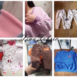 May include: A collage of various clothing items, including a pink sweatshirt with a white embroidered design, a pair of white sweatpants with a star design, a brown pair of trousers with a cartoon animal design, a pink and white floral onesie, and a blue sweatshirt with a red heart design.