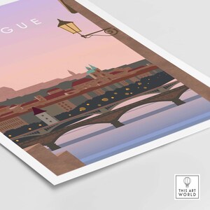 May include: A print featuring a stylized illustration of a cityscape with a bridge, buildings, and a river. The artwork has a warm color palette with shades of brown, orange, and blue. A street lamp is visible in the upper left corner. The text "GUE" is visible.