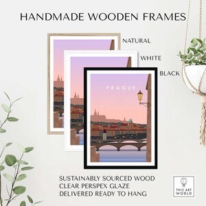 May include: Three framed art prints featuring a Prague cityscape illustration. The frames are natural wood, white, and black. The artwork depicts a bridge, buildings, and a soft pink and purple sky. Text on the image reads "HANDMADE WOODEN FRAMES" and "PRAGUE".