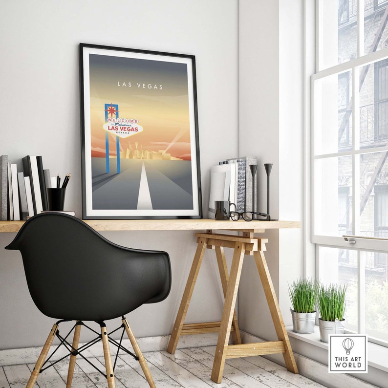 May include: A framed poster with a minimalist design featuring a stylized image of the "Welcome to Fabulous Las Vegas" sign with a road leading to the city skyline. The poster is titled "Las Vegas" and is displayed on a desk with a black chair and a wooden easel.