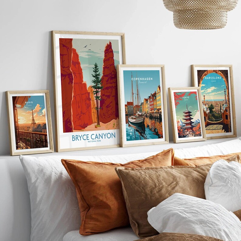 Travel and national park art prints in natural wood frames above a bed with decorative pillows