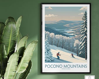 Op de afbeelding: Ingelijste kunstprint met een winterlandschap met skiërs op een besneeuwde helling. Het kunstwerk toont de Pocono Mountains in Pennsylvania, met besneeuwde bomen en verre heuvels onder een lichtblauwe hemel.