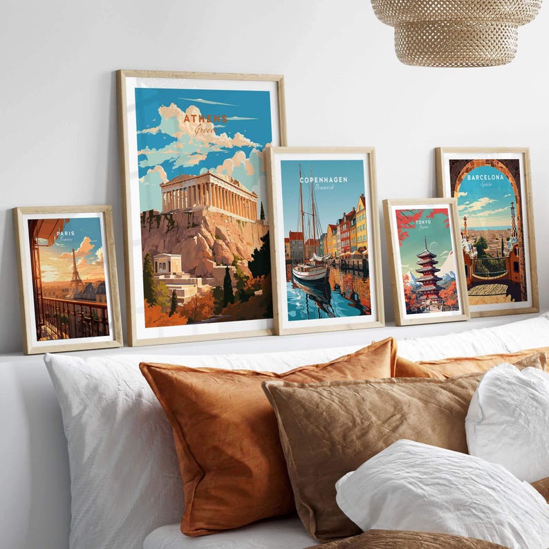 Collection of vibrant city posters featuring Athens, Copenhagen, and Barcelona above a cozy sofa with decorative pillows.