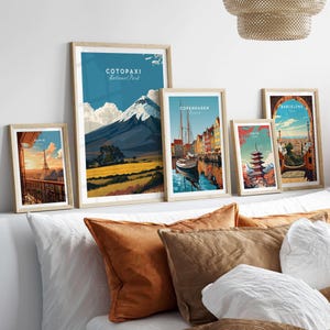 Framed travel posters including Cotopaxi National Park, Copenhagen, and Barcelona, displayed on a stylish shelf.