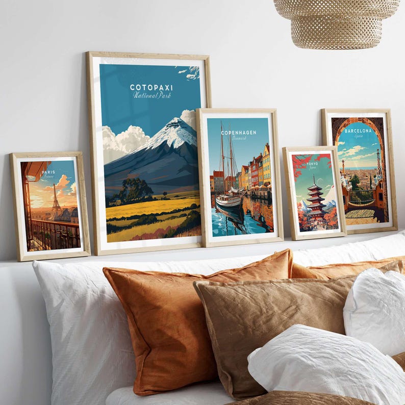 Framed travel posters including Cotopaxi National Park, Copenhagen, and Barcelona, displayed on a stylish shelf.