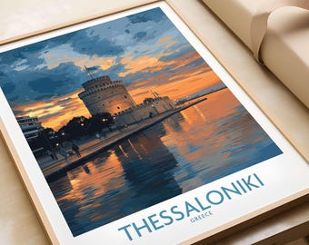Op de afbeelding: Een ingelijste print met de Witte Toren van Thessaloniki, Griekenland, bij zonsondergang. Het kunstwerk toont de toren en de waterkant in tinten oranje, blauw en goud, met de naam van de stad onderaan afgedrukt.