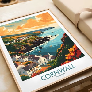 Puede incluir: Un póster de viaje de estilo vintage con una ilustración colorida de una ciudad costera en Cornualles, Inglaterra. El póster tiene un esquema de color azul, verde y naranja y presenta una ciudad costera con casas, un puerto y una masa de agua. El texto "CORNWALL ENGLAND" está impreso en azul en la parte inferior del póster.