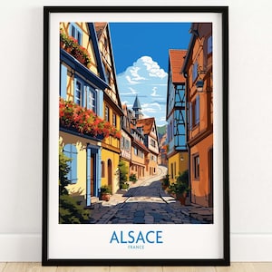 May include: A colorful illustration of a street in Alsace, France. The street is lined with traditional half-timbered houses with red flower boxes. The street is cobblestone and leads up a hill. The text "ALSACE FRANCE" is at the bottom of the image.