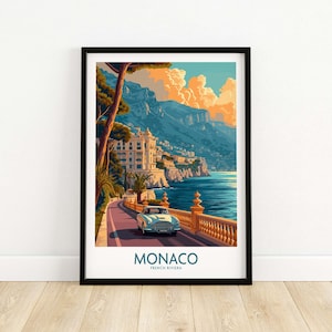 Op de afbeelding: Een vintage auto rijdt over een kronkelende weg in Monaco, Frankrijk. De weg is omzoomd met palmbomen en een stenen muur. De auto is lichtblauw en heeft een wit dak. De achtergrond is een schilderachtig uitzicht op de Middellandse Zee en de stad Monaco. De tekst "MONACO FRENCH RIVIERA" is onder de auto gedrukt.