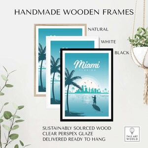 May include: A framed print of a Miami, Florida skyline with palm trees and a person paddleboarding in the water. The frame is available in natural, white, or black wood.
