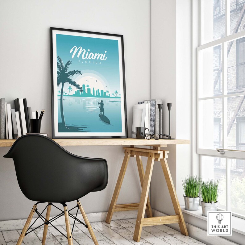 May include: A framed poster with a blue and green color scheme featuring a silhouette of a person paddleboarding in front of the Miami skyline. The poster has the text "Miami, Florida" at the top.