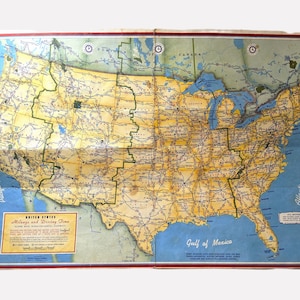 May include: Vintage United States map with mileage and driving time information. The map features a detailed depiction of the U.S. with roads, cities, and geographical features. The map is folded and has a blue and yellow color scheme.