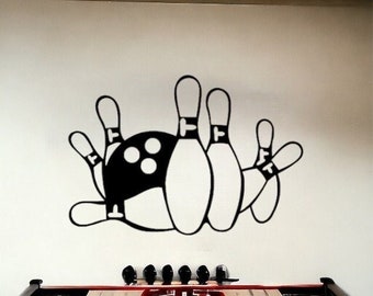 May include: Black and white wall decal of bowling pins and a bowling ball. The decal is on a white wall.