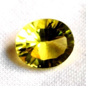 May include: A yellow faceted gemstone with a round shape.
