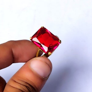 Puede incluir: Un anillo de oro con una gran piedra rectangular roja.
