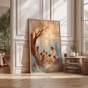May include: A framed art print depicts a religious scene with a central figure in white robes teaching a group of children under a tree. The artwork features warm tones of gold, brown, and blue, creating a serene and educational atmosphere.