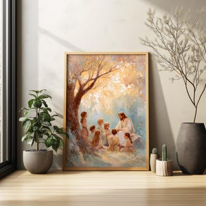 May include: A framed print depicts a religious scene with a central figure in white robes teaching a group of children under a tree. The artwork features warm tones of gold, brown, and blue, creating a serene and spiritual atmosphere. The frame is a light wood color.