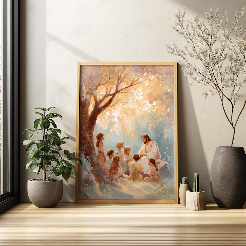 May include: A framed print depicts a religious scene with a central figure in white robes teaching a group of children under a tree. The artwork features warm tones of gold, brown, and blue, creating a serene and spiritual atmosphere. The frame is a light wood color.