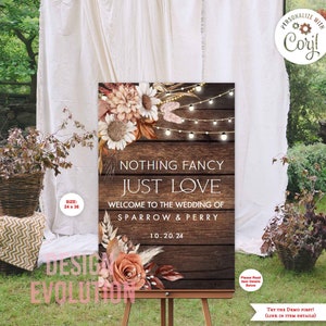 May include: A rustic wedding welcome sign with a woodgrain background and floral accents. The sign reads "Nothing Fancy Just Love" and "Welcome to the Wedding of Sparrow & Perry" with the date "10.20.24".