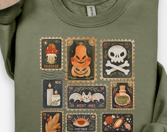 Può includere: Felpa verde militare con una serie di disegni di francobolli a tema Halloween. I francobolli raffigurano un fungo, zucche, un teschio e ossa incrociate, una candela, un pipistrello e una bottiglia di pozione. Il testo "NIGHT MAIL" è visibile.