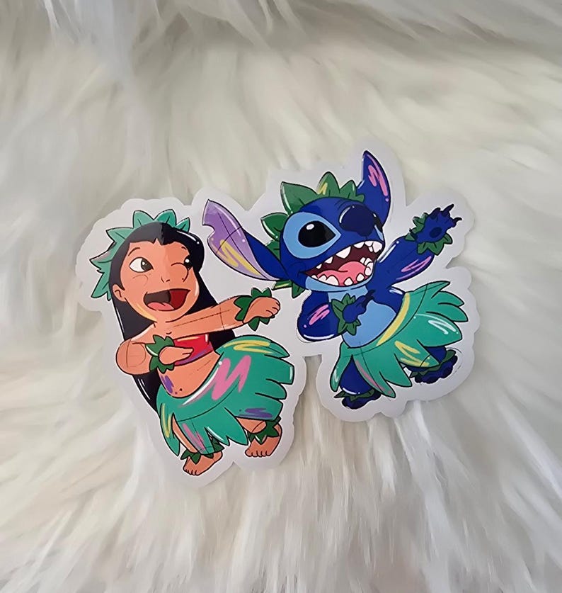 Puede incluir: Dos pegatinas de dibujos animados de Stitch y Lilo de la pel&iacute;cula de Disney Lilo & Stitch. Stitch es azul y lleva un collar de flores verde y una falda de hierba. Lilo lleva una camiseta roja y una falda de hierba verde con detalles rosas y morados.