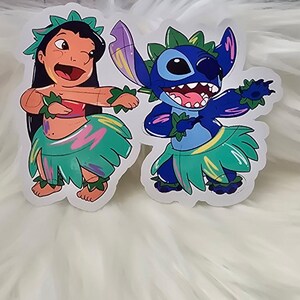 Puede incluir: Dos pegatinas coloridas con Lilo y Stitch de la pel&iacute;cula de Disney Lilo & Stitch. Lilo lleva una falda de hierba verde y rosa y un collar de flores. Stitch lleva una falda de hierba azul con un patr&oacute;n verde y amarillo. Ambos personajes sonr&iacute;en y tienen los brazos levantados en el aire.