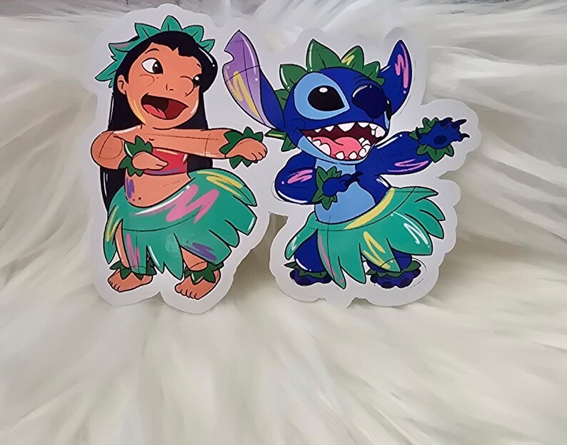 Puede incluir: Dos pegatinas coloridas con Lilo y Stitch de la pel&iacute;cula de Disney Lilo & Stitch. Lilo lleva una falda de hierba verde y rosa y un collar de flores. Stitch lleva una falda de hierba azul con un patr&oacute;n verde y amarillo. Ambos personajes sonr&iacute;en y tienen los brazos levantados en el aire.