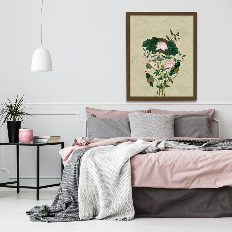 May include: A framed print of a botanical illustration featuring a pink lotus flower with green leaves on a beige background.