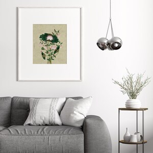 May include: A framed print of a botanical illustration featuring a pink flower with green leaves on a beige background.