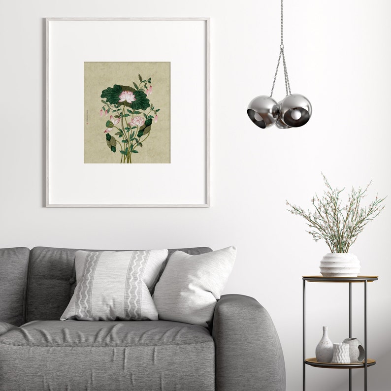 May include: A framed print of a botanical illustration featuring a pink flower with green leaves on a beige background.